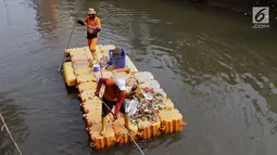 Petugas UPK Badan Air Pemprov DKI Jakarta membersihkan ceceran sampah di sepanjang Anak Sungai Ciliwung yang membelah kawasan Jalan Gajah Mada dan Hayam Wuruk, Selasa (9/7/2019). Pembersihan ini untuk menghindari penumpukan sampah dan memperlancar aliran air. (Liputan6.com/Helmi Fithriansyah)