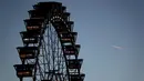 Sebuah wahana kincir angin diterangi selama berlangsungnya festival bir Oktoberfest di Munich, 27 September 2018. Oktoberfest adalah rangkaian festival terbesar di dunia yang diadakan setiap tahun oleh masyarakat Jerman. (AP/Matthias Schrader)