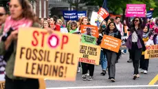 Para pengunjuk rasa berjalan kaki sambil melakukan aksi protes di sekitar lokasi Pertemuan Musim Semi IMF-Bank Dunia di Pennsylvania Ave menuju gedung International Finance Corporation pada 19 April 2024 di Washington DC. (Kent Nishimura/Getty Images North America/Getty Images via AFP)