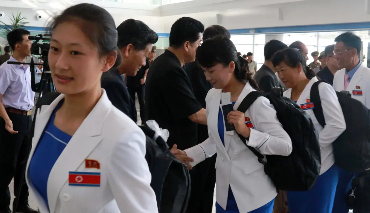 Atlet Korea Utara yang dikepalai Wakil Menteri Olahraga Korea Utara, Won Kil U bersiap meninggalkan bandara internasional Pyongyang, Korut (10/8). Korut akan berpartisipasi dalam Asian Games 2018 di Jakarta dan Palembang, Indonesia. (AP Photo/Cha Song Ho)