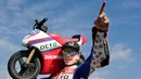 Pembalap MotoGP Scott Redding berpose dengan motor listrik mini saat acara jumpa pers jelang MotoGP Jepang di sirkuit Twin Ring Motegi, Jepang (12/10). (AP Photo / Shizuo Kambayashi)