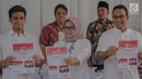Gubernur DKI Anies Baswedan bersama istri Fery Farhati Ganis dan anaknya menunjukkan surat suara sebelum mencoblosnya di TPS 60, Cilandak, Jakarta Selatan, Rabu (17/4). Adapun pencoblosan Pemilu 2019 dilakukan serentak hari ini pada pukul 07.00-13.00 waktu setempat. (Liputan6.com/Faizal Fanani)