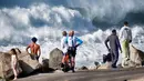 Pengunjung menyaksikan ombak menghantam pantai di Pantai Manhattan, California, Amerika Serikat, Kamis (28/12/2023). Badan Cuaca Nasional AS telah mengeluarkan peringatan gelombang tinggi di sebagian besar Pantai Barat dan sebagian Hawaii. (AP Photo/Richard Vogel)