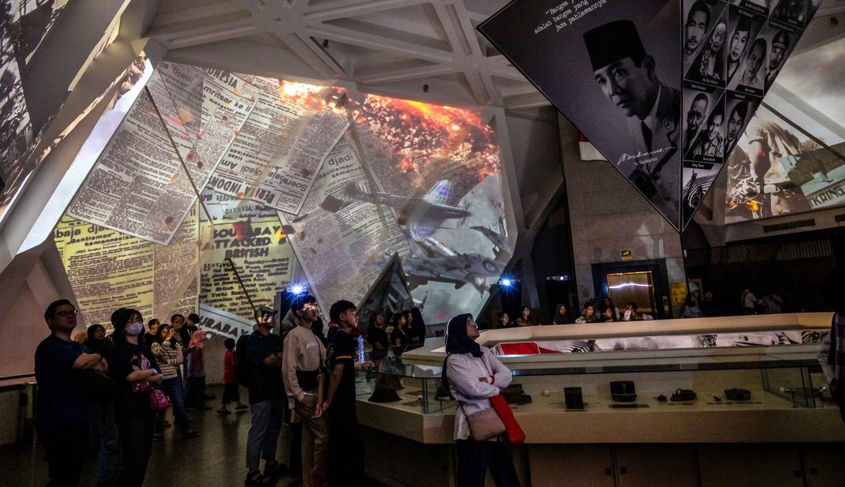 Pengunjung menyaksikan video imersif yang menggambarkan Pertempuran Surabaya, yang terjadi pada bulan November 1945 antara pejuang Indonesia melawan pasukan Sekutu Inggris dan NICA untuk menegakkan kembali kekuasaan kolonial Belanda setelah berakhirnya Perang Dunia II, dalam acara 'Malam di Museum 2025' di Museum 10 November, Surabaya, Jawa Timur, Sabtu 29 November 2025. (Juni KRISWANTO/AFP)
