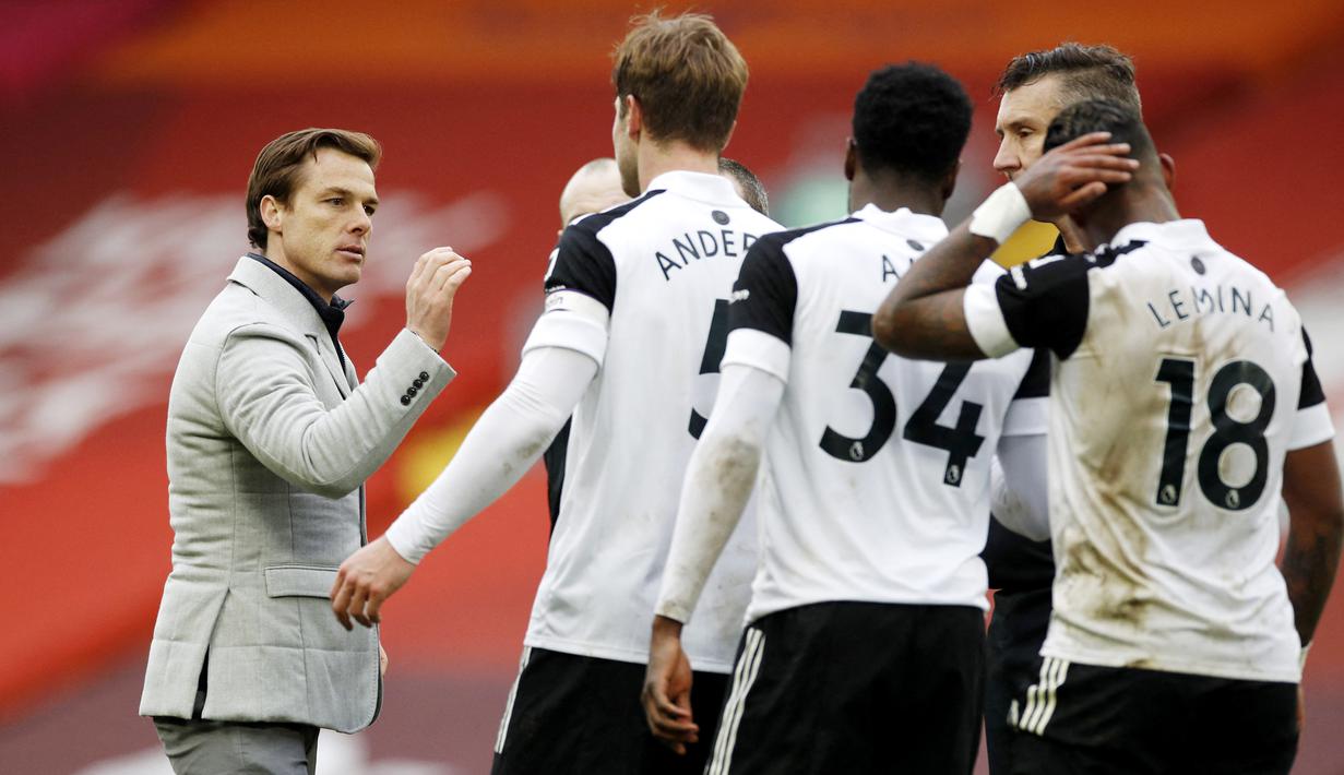 Pelatih Fulham, Scott Parker, memberikan selamat kepada anak asuhnya usai berhasil menaklukkan Liverpool pada laga Liga Inggris di Stadion Anfield, Minggu (7/3/2021). Fulham menang dengan skor 0-1. (Phil Noble/Pool/AFP)