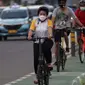 Warga mengenakan masker bersepeda di jalan Jenderal Sudirman, Jakarta, Jumat (25/6/2021). Hari ini Jumat (25/6), Provinsi DKI Jakarta mencatat penambahan kasus konfirmasi positif Covid-19 sebanyak 6.934 orang. (Liputan6.com/Helmi Fithriansyah)