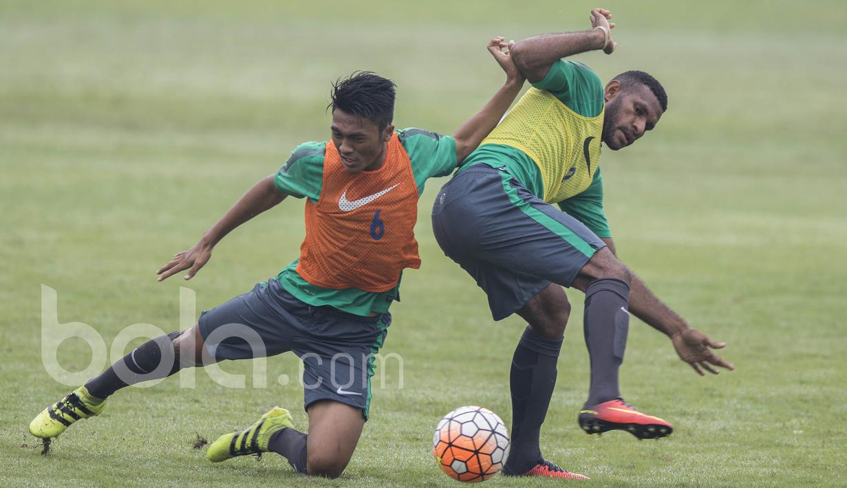 Bek Madura United, Rizky Dwi Febriyanto, berebut bola dengan striker Persipura Jayapura, Marianus Wanewar, saat seleksi Timnas Indonesia U-22 di Lapangan SPH Karawaci, Banten, Kamis (23/2/2017). (Bola.com/Vitalis Yogi Trisna)