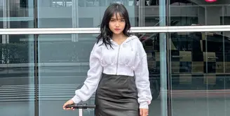 Fuji an memadukan midi skirt leather hitam dengan jaket crop top warna putih dan sneakersnya. [@fuji_an]