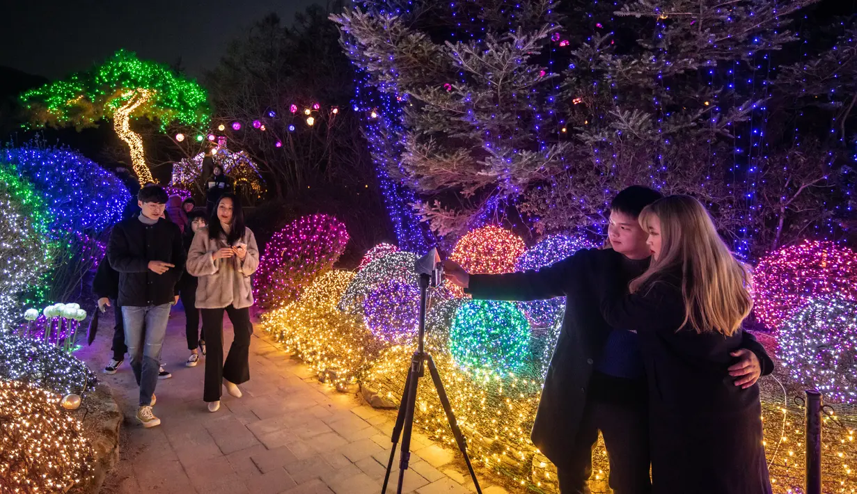 Gambar pada 11 Januari 2020, pengunjung berswafoto saat menyaksikan keindahan ribuan lampu di Garden of Morning Calm, sebelah timur Seoul di distrik Gapyeong, Korea Selatan. Festival cahaya tahunan tersebut dinikmati saat musim dingin, Desember sampai akhir bulan Maret. (Ed JONES / AFP)