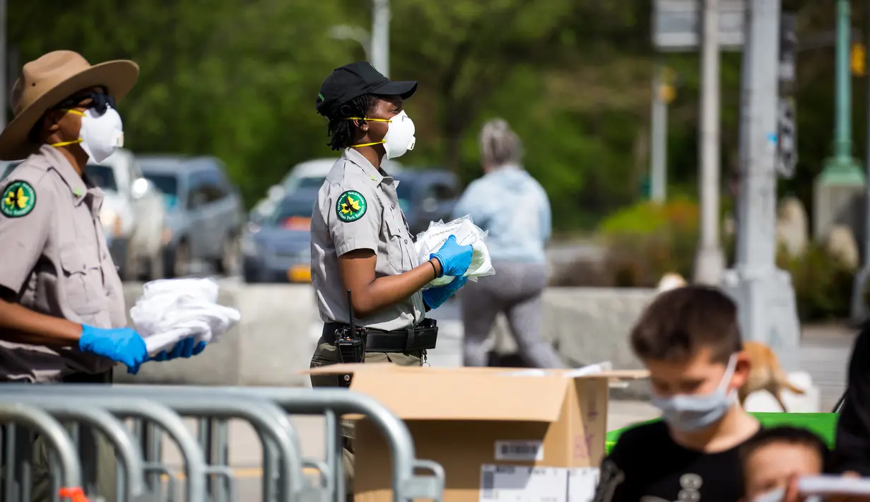 Petugas jagawana taman kota New York City membagikan masker gratis di Prospect Park di wilayah Brooklyn di New York, Amerika Serikat (3/5/2020). Menurut panduan dari Departemen Kesehatan NYC, semua warga New York diwajibkan mengenakan masker atau penutup wajah. (Xinhua/Michael Nagle)