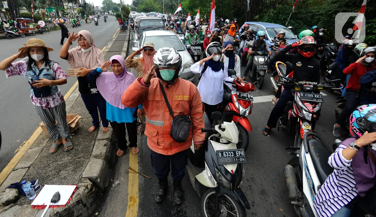 Pengguna jalan melakukan penghormatan saat detik-detik proklamasi 17 Agustus di ruas jalan protokol Jakarta-Bogor, pertigaan Cibinong, Bogor, Jawa Barat, Rabu (17/8/2022). Sejumlah pengguna jalan terlihat turun dari kendaraannya dan melakukan sikap hormat. (merdeka.com/Arie Basuki)