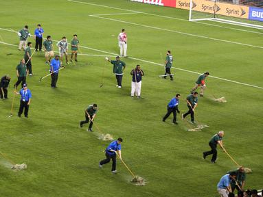 Petugas membersihkan genangan air akibat hujan badai yang menunda laga Cile melawan Kolombia dalam semifinal Copa America Centenario 2016 di Stadion Soldier Field, Chicago, AS, Kamis (23/6/2016) pagi WIB. (AFP/Tasos Katopodis)