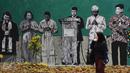 Warga melintas di depan gambar pemimpin agama di Lapangan Kebagusan, Jakarta, Rabu (15/2). Jelang menggunakan hak pilihnya pada Pilkada, Ketua Umum PDI-P Megawati Soekarnoputri menggoreskan tinta pada salah satu gambar. (Liputan6.com/Helmi Fithriansyah)