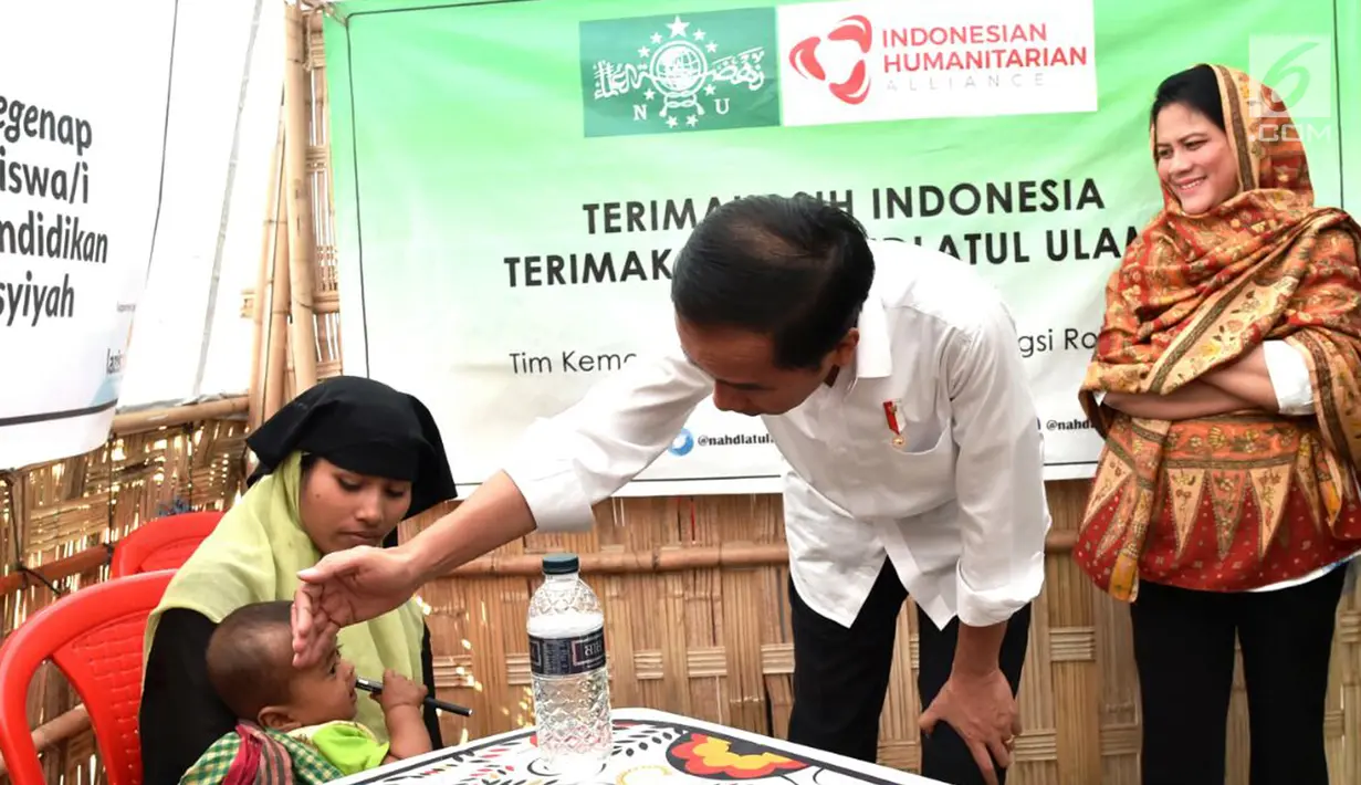 Presiden Jokowi mengecek kesehatan seorang bayi di pengungsian Rahkhine State, Kamp Jamtoli, Bangladesh, Minggu (28/1). Jokowi mengapresiasi semua pihak yang mendukung pemerintah membantu pengungsi Rohingya. (Liputan6.com/Pool/Rusman Biro Pers Setpres)