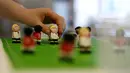 Pembuat kue meletakkan hiasan di atas kue Euro 2016 yang dibuat di sebuah tempat pembuatan kue di Munich, Jerman, Senin (20/6). Beraneka kue bertema Euro 2016 mewarnai perhelatan sepakbola Eropa. (REUTERS/Michaela Rehle)