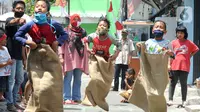 Anak-anak mengikuti lomba balap karung saat acara kegiatan tujuh belas Agustus di Cinere, Depok, Senin (17/8/2020). Warga di sejumlah kampung di wilayah Jabodetabek tetap melakukan beragam kegiatan lomba memperingati HUT ke-75 RI dengan menerapkan protokol kesehatan. (merdeka.com/Arie Basuki)