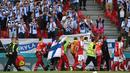 Bendera Finlandia juga menjadi salah satu pahlwan bagi Eriksen. Bendera yang diberikan oleh salah satu suporter Finladia itu berjasa untuk menutupi keadaan Eriksen yang terkulai lemas dari seisi Stadion Parken. (Foto: AFP/Pool/Jonathan Nackstrand)