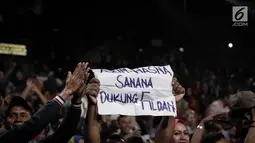 Pendukung Fildan membawa poster saat menonton jagoannya dalam grand final Dangdut Academy 4 atau D'Academy 4 di Studio 5 Indosiar, Jakarta, Jumat (19/5). (Liputan6.com/Faizal Fanani)