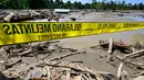Banyak rumah warga hancur dan nyaris rata dengan tanah, meninggalkan puing-puing beton dan kayu berserakan. Tampak dalam foto, garis polisi terlihat di atas lumpur dan puing-puing di daerah terdampak banjir di Meureudu, Kabupaten Pidie Jaya, Provinsi Aceh, pada 30 November 2025. (CHAIDEER MAHYUDDIN/AFP)