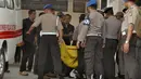 Kantong jenzah dibawa masuk petugas kepolisian ke ruang jenazah di RS Bhayangkara Palu, Sulawesi Tengah, Selasa (17/7). Dua jenazah diduga teroris Santoso alias Abu Warda dan Muhtar yang tewas dalam baku tembak itu akan diidentifikasi. (OLAGONDRONK/AFP)