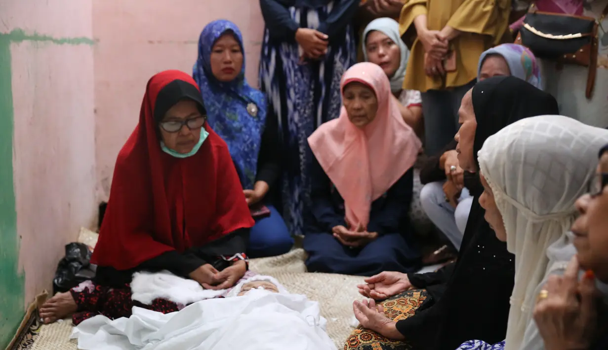 Pagi tadi, sebelum dimakamkan jenazah Laila Sari usai dimandikan kemudian dibalut dengan kain kafan. Dikelilingi keluarga dan warga sekitar, lantunan ayat suci pun terdengar yang ditujukan untuk Laila Sari. (Adrian Putra/Bintang.com)