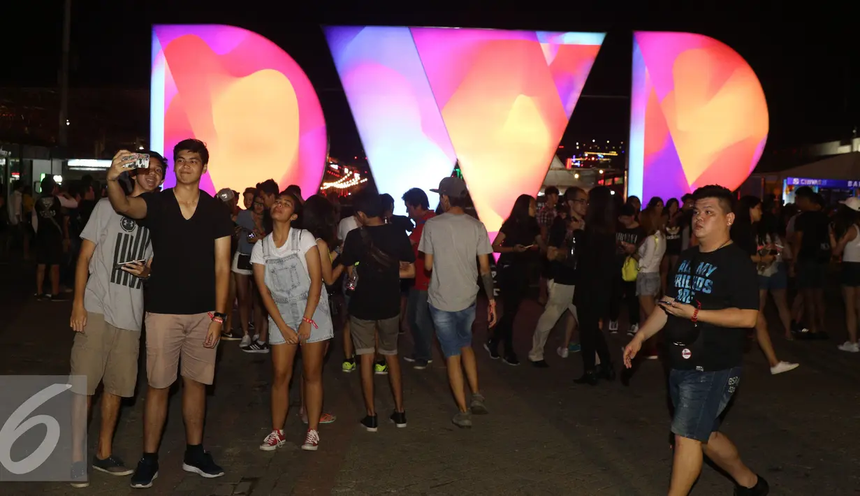 Sejumlah orang berselfie saat menonton acara festival musik Djakarta Warehouse Project (DWP) 2016 di Jiexpo Kemayoran, Jakarta, Jumat (10/12). Acara ini digelar selama dua hari, tanggal 9 dan 10 Desember kemarin. (Liputan6.com/Herman Zakharia)