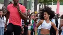 2.	Sprinter Jamaika juara Olimpiade,Usain Bolt, berlomba dengan anak-anak saat mengunjungi kompleks olah raga Mangueira, Rio de Janeiro, Brasil. Jumat (16/4)