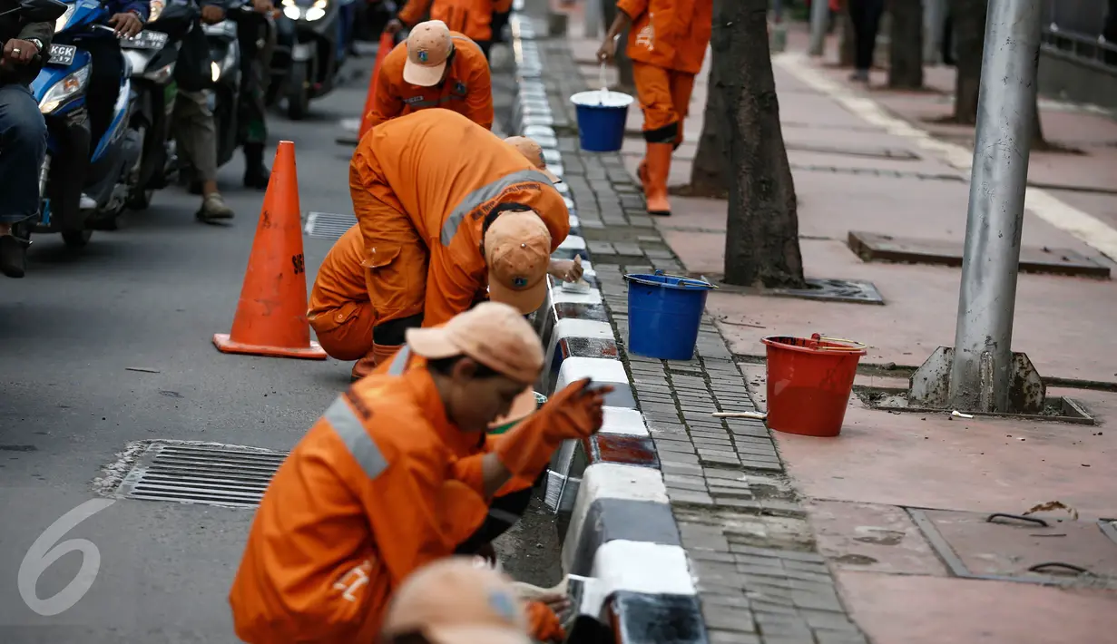 Petugas dari Kelurahan Karet Semanggi mengecat trotoar di kawasan Jalan Semanggi, Jakarta, Selasa (1/3/2016). Trotoar itu dipercantik dengan dicat ulang oleh Petugas Prasarana Sarana Umum (PPSU). (Liputan6.com/Faizal Fanani)