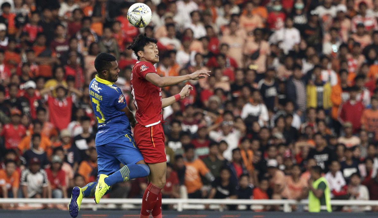 Striker Persija Jakarta, Feby Eka, berduel bola atas dengan pemain Persib Bandung pada laga Shopee Liga 1 di SUGBK, Jakarta, Rabu (10/7). Persija bermain imbang 1-1 atas Persib. (Bola.com/Yoppy Renato)