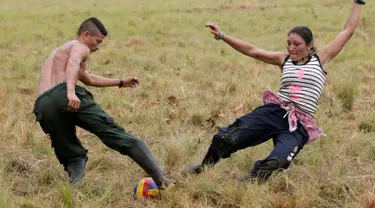 Pejuang dari Angkatan Bersenjata Revolusioner Kolombia (FARC) bermain sepak bola di sebuah kamp di mana mereka mempersiapkan diri untuk meratifikasi kesepakatan damai dengan pemerintah, di Yari Plains, Kolombia, (19/9). (REUTERS/John Vizcaino)