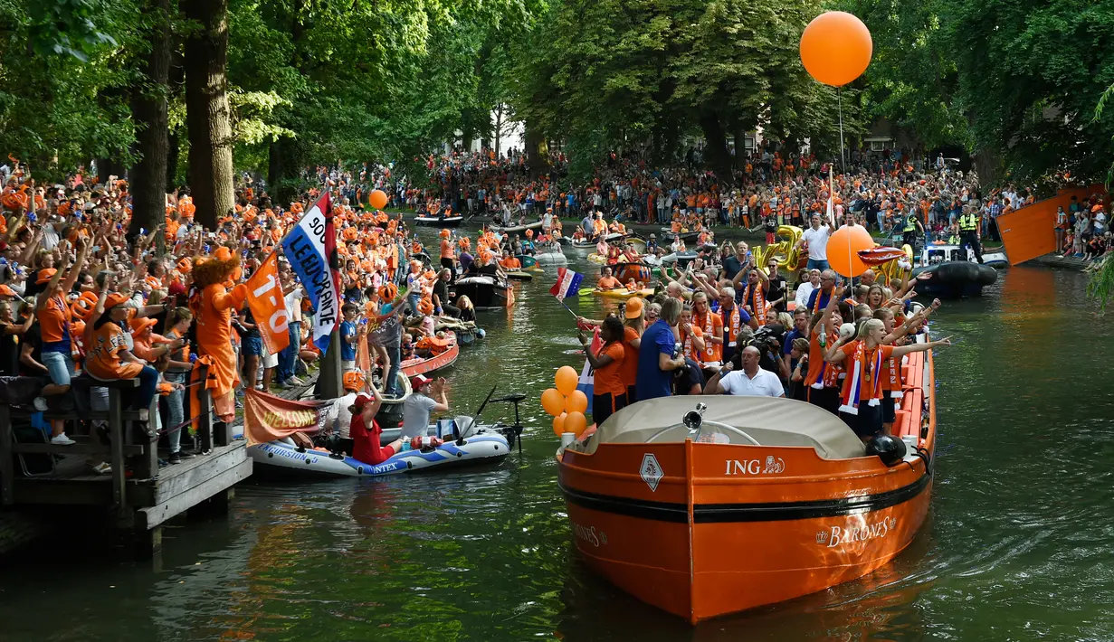 Suasana keramaian saat tim sepak bola wanita Belanda merayakan kemenangan bersama para pendukung di sebuah perahu di Utrecht, Belanda (7/9). (AFP Photo/John Thys)