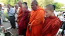 Sejumlah biksu bersama warga berdoa di depan sebuah stupa yang berisi ratusan tengkorak manusia dan tulang korban rezim Khmer Merah di Choeung Ek memorial, Kamboja (17/4). (AP Photo/Heng Sinith)