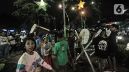 Anak-anak memainkan bedug saat merayakan malam takbiran Idul Fitri di Manggarai, Jakarta, Rabu (13/5/2021). Tradisi merayakan malam takbiran dengan memainkan bedug dan membuat hiasan bernuansa Islam masih terlihat di pinggiran Ibu Kota meski pandemi Covid-19. (merdeka.com/Iqbal S. Nugroho)