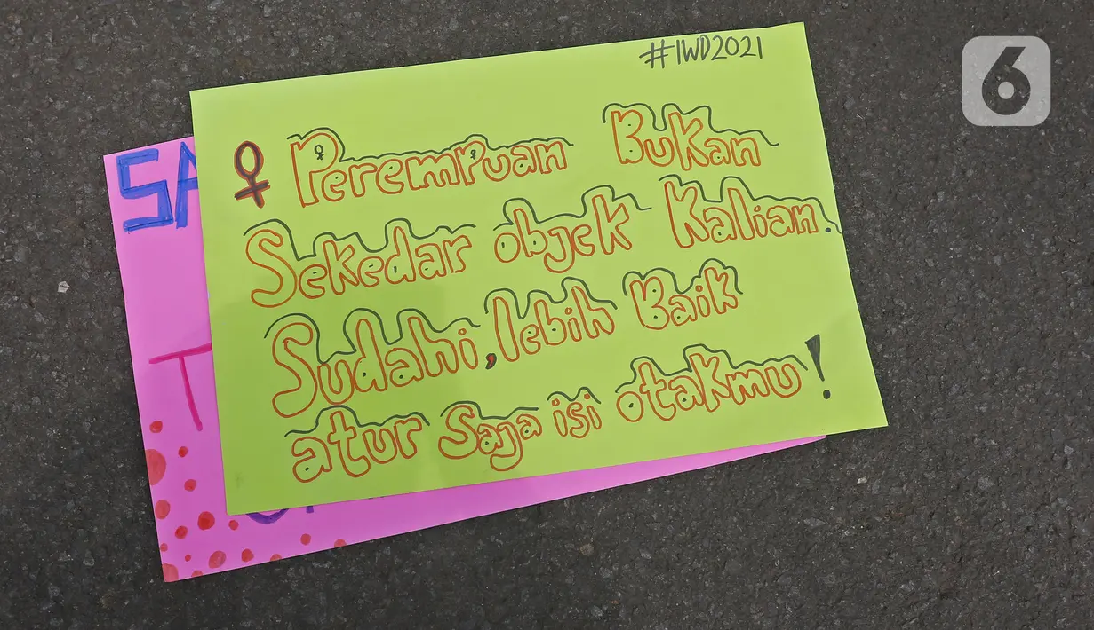 Poster dalam aksi yang digelar untuk memperingati Hari Perempuan Sedunia di Kawasan Patung Kuda Arjuna Wijaya, Jakarta, Senin (8/3/2021). Mereka meminta segera pemerintah mengesahkan RUU Perlindungan PRT, Ratifikasi Konvensi ILO 190 beserta rekomendasi 206. (Liputan6.com/Herman Zakharia)
