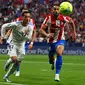 Pemain depan Real Madrid Lucas Vazquez (kiri) berebut bola dengan penyerang Atletico Madrid Matheus Cunha dalam laga pekan ke-35 Liga Spanyol di Wanda Metropolitano, Senin (9/5/2022) dini hari WIB. Atletico Madrid berhasil menang dengan skor tipis 1-0 atas Real Madrid. (GABRIEL BOUYS / AFP)