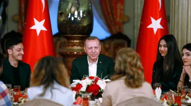 Gelandang Arsenal, Mesut Ozil didampingi kekasihnya Amine Gulse saat menghadiri acara buka puasa bersama dengan Presiden Turki Recep Tayyip Erdogan di Istana Dolmabahce, Istanbul, Turki (19/5). (Stringer/Turkish President's Press Office/AFP)