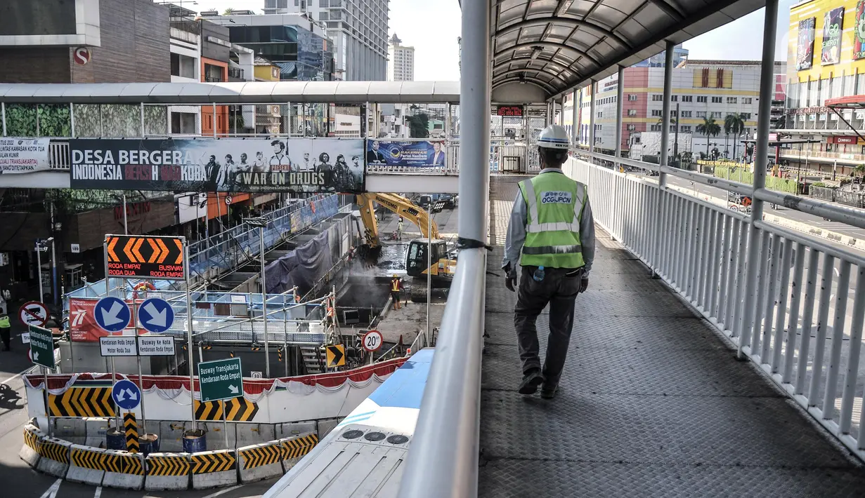 Aktivitas pekerja saat menyelesaikan proyek pembangunan jalur Mass Rapid Transit (MRT) Fase 2A-CP203 rute Bundaran HI-Kota Tua di Jalan Gajah Mada, Jakarta Barat, Minggu (11/9/2022). Gubernur DKI Jakarta Anies Baswedan mengungkapkan, pembangunan jalur kereta cepat MRT fase 2A rute Stasiun Bundaran Hotel Indonesia (HI)-Kota Tua yang memiliki panjang 6,3 kilometer tersebut ditargetkan rampung pada 2028. (merdeka.com/Iqbal S. Nugroho)