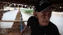 Seorang tim ekspedisi tertua saat memegang stir kendali diatas kapal ekspedisi napak tilas "Spirit of Majapahit" di Dermaga Marina Ancol, Jakarta, Rabu (11/5). (Liputan6.com/Faizal Fanani)