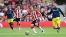 Pemain Southampton Oriol Romeu (tengah) mengontrol bola di depan bek Manchester United Luke Shaw (kanan) pada pertandingan Liga Inggris di Stadion St Mary, Southampton, Inggris, 22 Agustus 2021. Pertandingan berakhir imbang 1-1. (Glyn KIRK/AFP)
