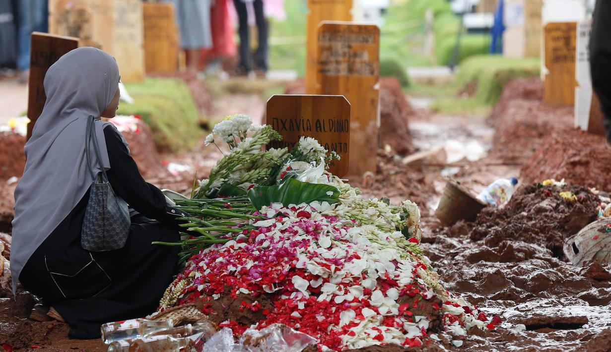 Salah satu kerabat bersimpuh di sisi makam Oxavia Aldiano atau lebih dikenal dengan nama Vidi Aldiano di Tempat Pemakaman Umum (TPU) Tanah Kusir, Jakarta, Minggu (8/3/2026). (Kapanlagi.com/Budy Santoso)