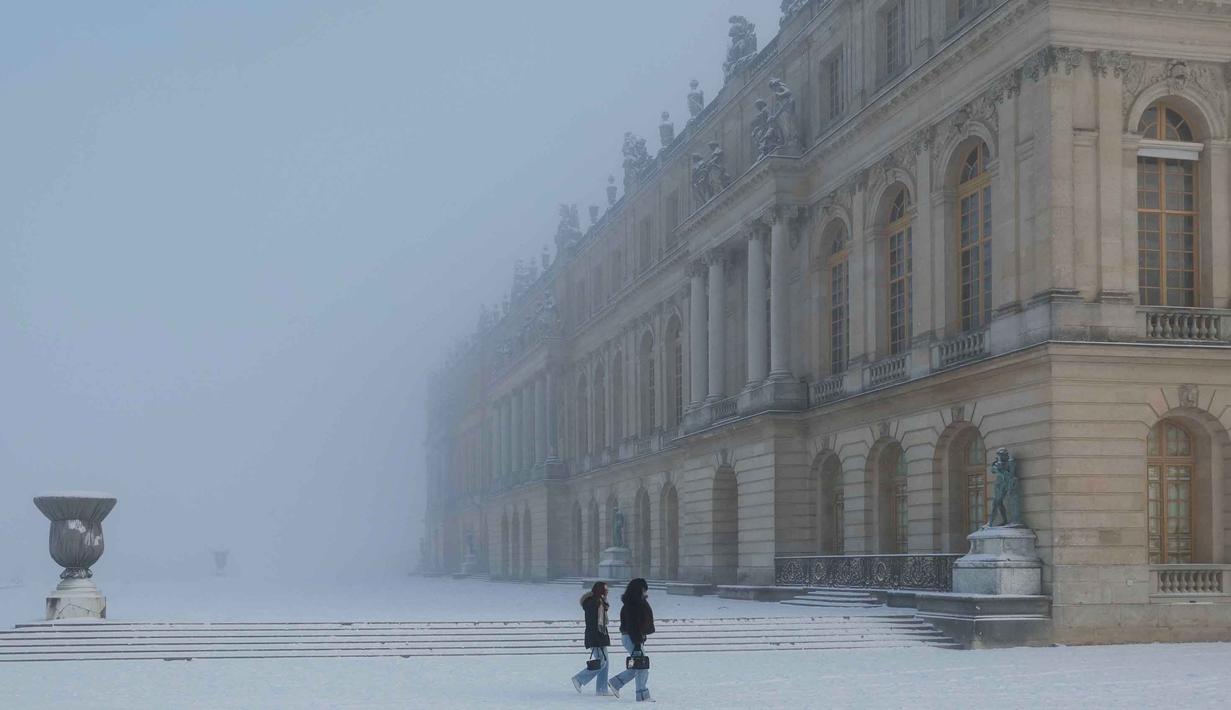 Kondisi ini sangat berbahaya bagi pengendara maupun pejalan kaki di ibu kota Prancis tersebut. Tampak dalam foto, pejalan kaki berjalan melintasi taman Versailles yang tertutup salju, luar Kota Paris pada Selasa 6 Januari 2026. (GEOFFROY VAN DER HASSELT/AFP)