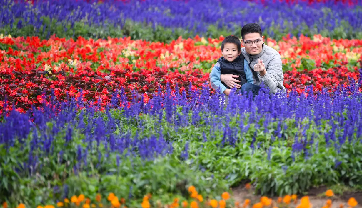 Sejumlah wisatawan berpose untuk difoto di antara bunga-bunga di Taman Hutan Nasional Shimen, Guangzhou, Provinsi Guangdong, China, 26 Desember 2020. (Xinhua/Deng Hua)