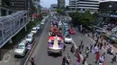 Sejumlah warga melihat Iring-iringan mobil karnaval para pasangan Cagub DKI Jakarta saat melintas di Thamrin, Jakarta, Sabtu (29/10). Karnaval tersebut merupakan bentuk kampanye damai untuk pemilihan Gubernur DKI Jakarta. (Liputan6.com/Angga Yuniar)