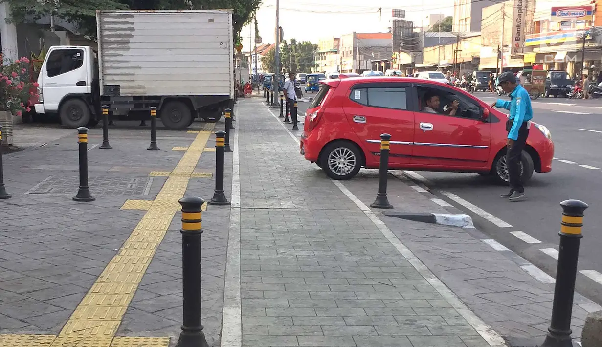 Truk menutup sebagian badan trotoar di kawasan Jatinegara, Jakarta, Senin (24/9). Kondisi trotoar yang telah diperlebar Pemprov DKI Jakarta kini dipenuhi PKL dan parkir liar sehingga mengganggu kenyamanan pejalan kaki. (Liputan6.com/Immanuel Antonius)