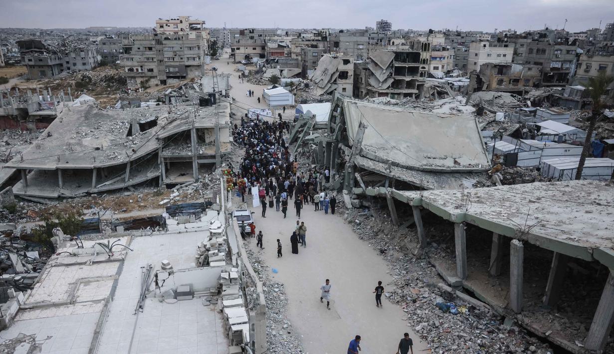 Warga Palestina berkumpul di jalan yang rusak parah untuk melaksanakan salat menandai dimulainya Idul Adha, Hari Raya Kurban, di Khan Yunis di Jalur Gaza Selatan, pada Rabu 27 Mei 2026. (BASHAR TALEB/AFP)