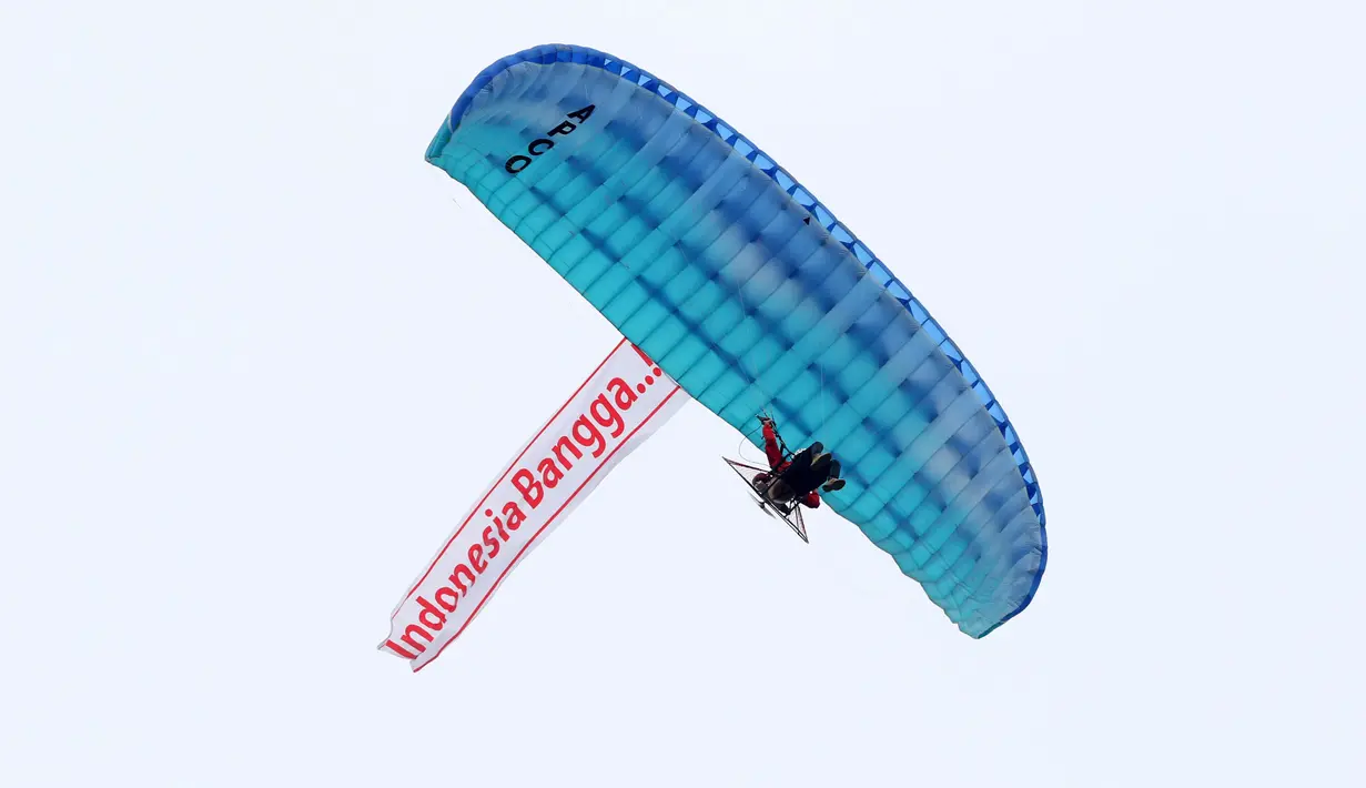Aksi paramotor yang terbang membawa slogan 'Indonesia Bangga..!' pada peluncuran Logo Asian Games 18th di Senayan, jakarta, Sabtu (27/12/2015). (Bola.com/Nicklas Hanoatubun) 