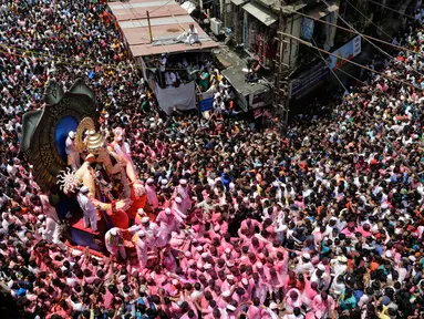 Umat hindu India mengarak patung dewa Ganesha menuju Laut Arab saat Ganesha Chaturthi di Mumbai, India, Selasa (5/9). Dalam festival ini, seluruh umat hindu India memperingati hari lahir Dewa Ganesha. (Mahesh Kumar A/AP Photo)