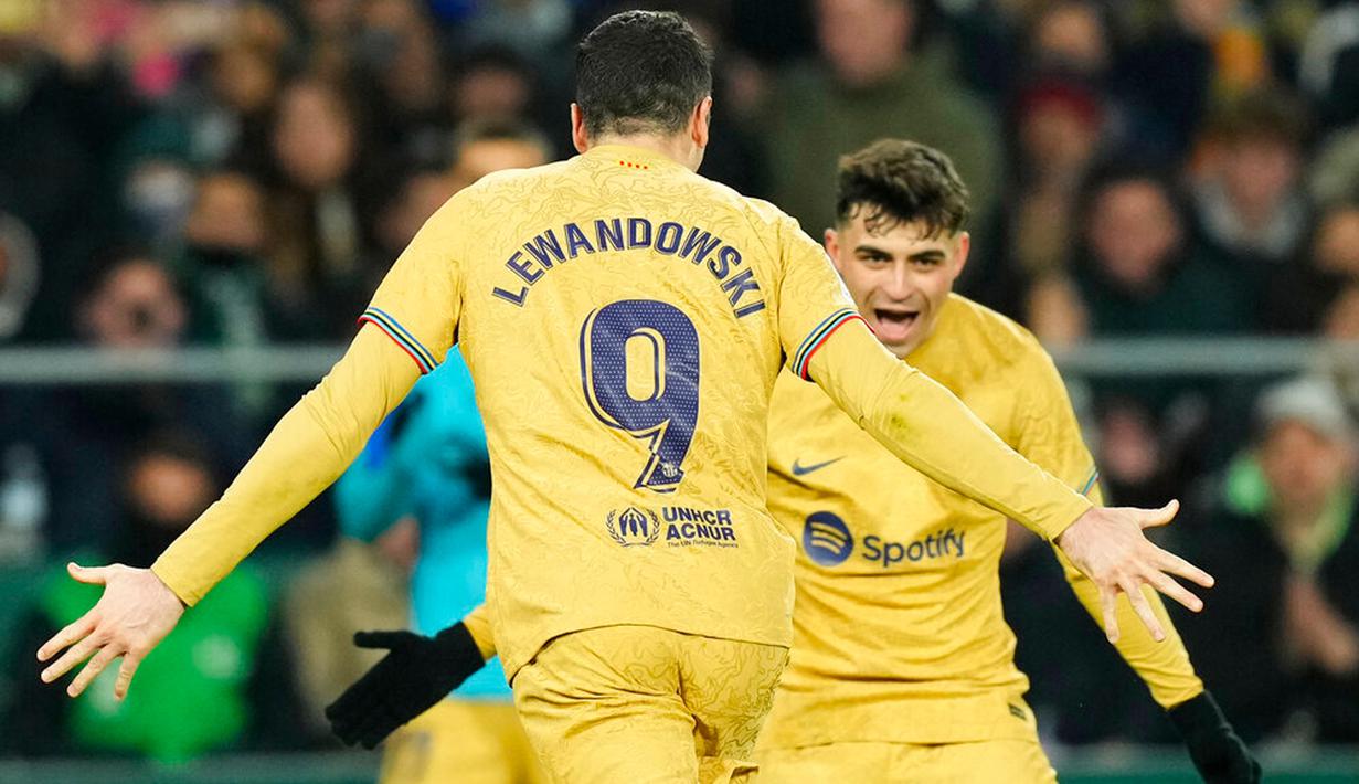 Pemain Barcelona Robert Lewandowski (kiri) merayakan dengan rekan setimnya Pedri usai mencetak gol ke gawang Real Betis pada pertandingan sepak bola Liga Spanyol di Stadion Benito Villamarin, Seville, Spanyol, 1 Februari 2023. Barcelona genap mengoleksi 50 poin dan unggul 8 poin dari Real Madrid usai menang 2-1 atas Real Betis pada lanjutan Liga Spanyol. (AP Photo/Jose Breton)