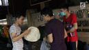 Pencari suaka berbagi makanan di atas trotoar depan Masjid Ar-Rayan, Jalan Kebon Sirih, Jakarta, Jumat (5/7/2019). Para pencari suaka dari sejumlah negara berkonflik berharap UNHCR bisa segera memberikan jaminan perlindungan bagi mereka. (Liputan6.com/Helmi Fithriansyah)