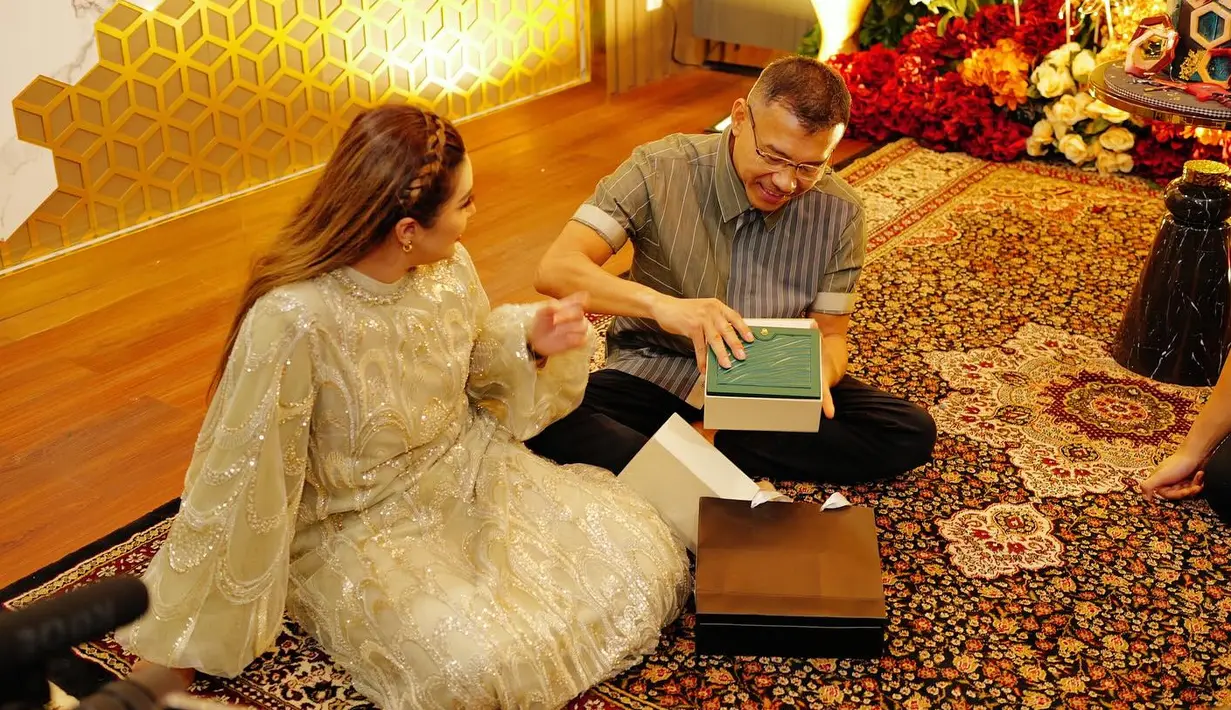 <p>Anang Hermansyah tampak antusias membuka kado pemberian keluarganya. Kado tersebut terbungkus di dalam kotak cantik berwarna putih dan hijau. (foto: Instagram/ attahalilintar)</p>